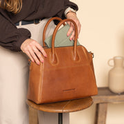 Styled Fit Perspective of Marsala Full-Grain Leather Handbag on Model - Natural Daylight Drape